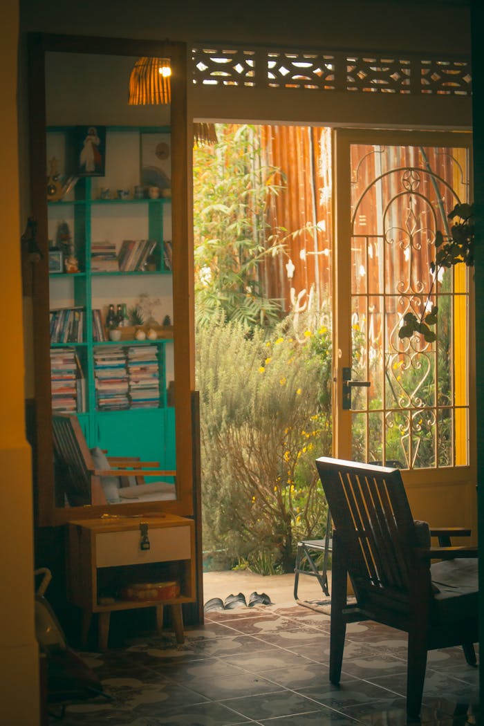 Inviting interior with colorful bookcase and open door leading to a lush garden view.