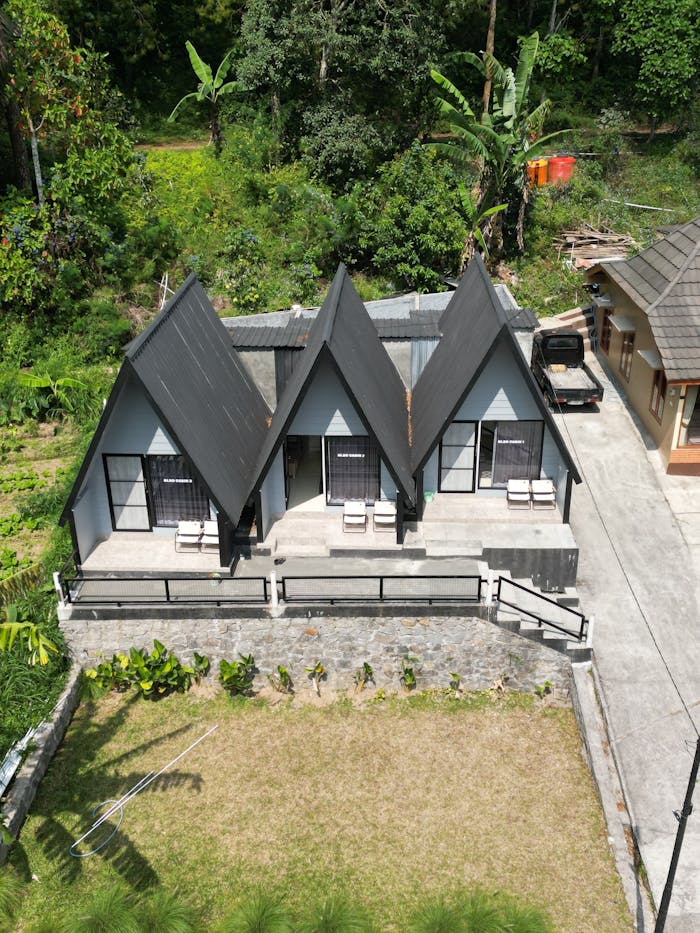Aerial view of A-frame cottages surrounded by greenery, ideal for a serene getaway.